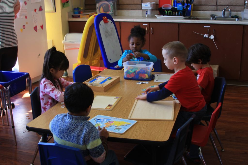Children playing with puzzles at Creative Learners Child Care in Pleasanton, CA. Developing cognitive and fine motor skills in our preschool.